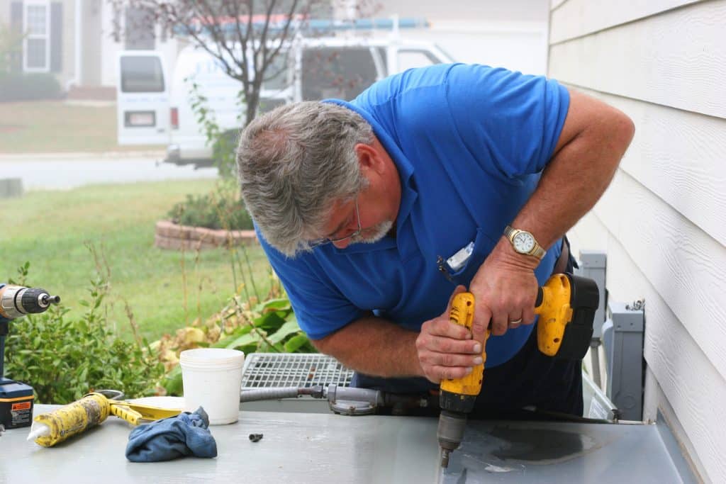 AC Repair 9 showing a Man Drilling a Table with a Drill