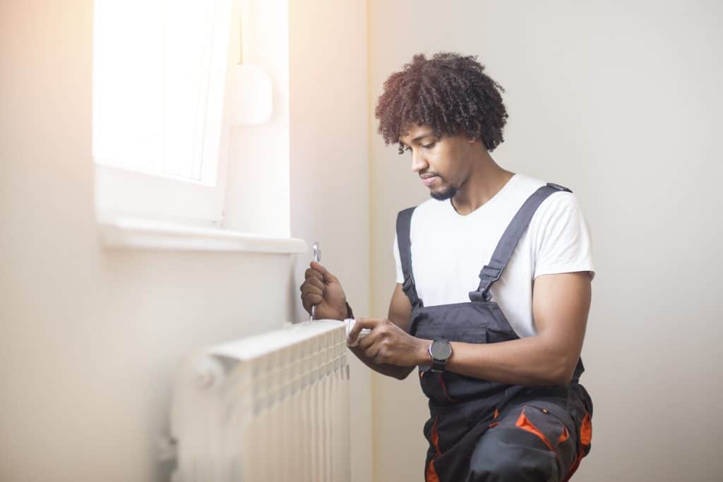 Young man fixing heating