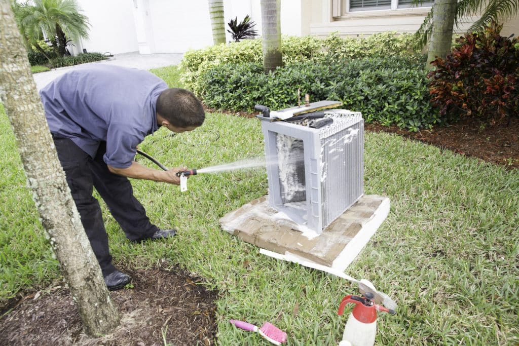 AC repairman acid washing air conditioner coils