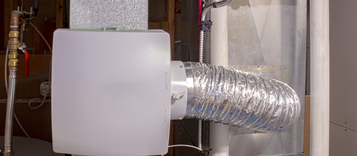 A home humidifier attached to the return duct with a bypass connection to the supply hot air duct.
