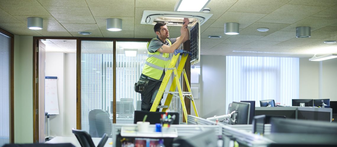 air con maintenance engineer in empty office floor